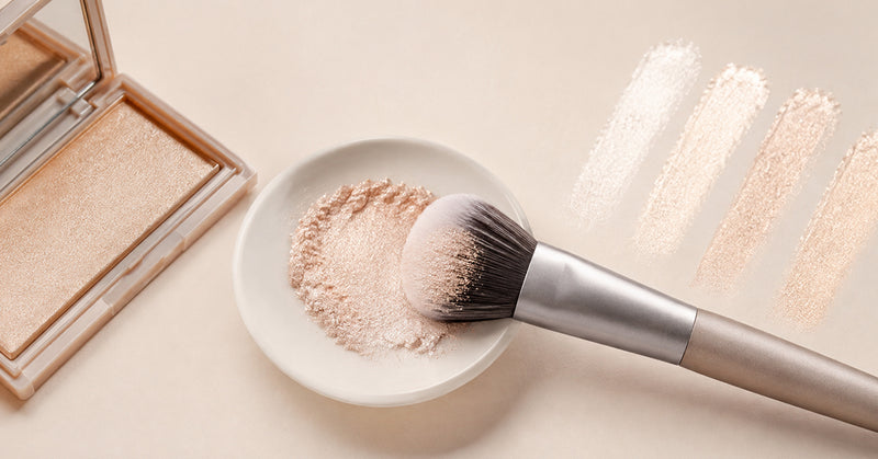 Woman applying highlighter to her cheekbone with a small makeup brush for a natural glow