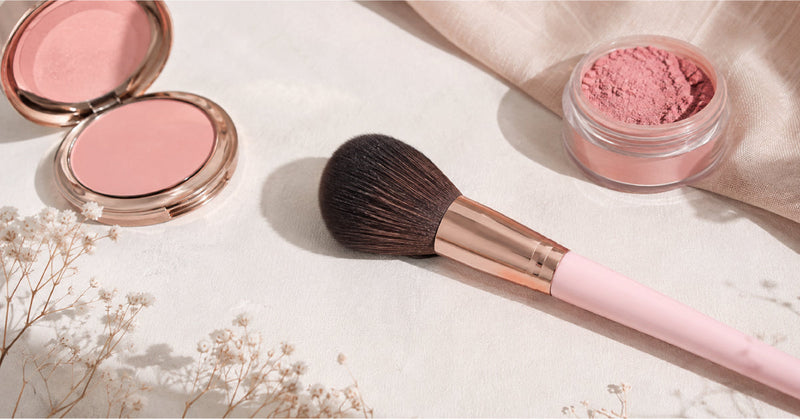 Makeup artist applying powder blush with a fluffy brush for a natural flush